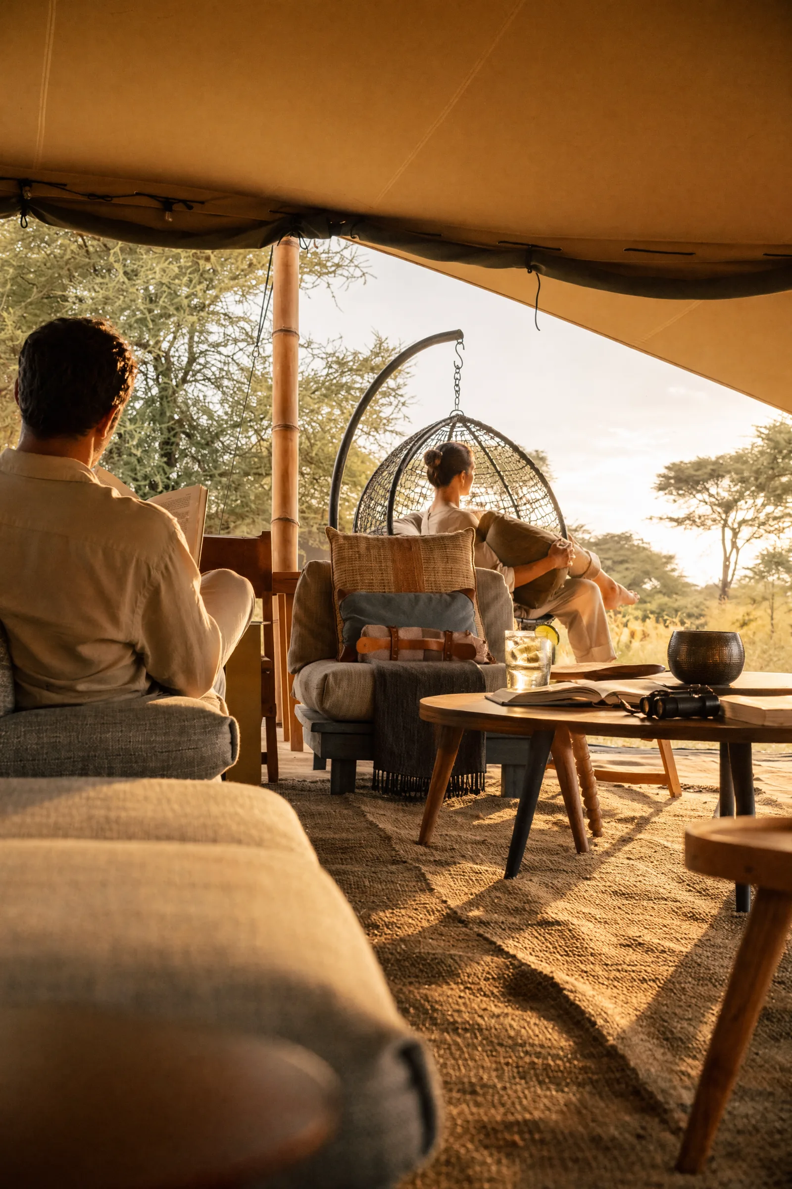After: Safari-Tent-Lounge mit hängendem Rattan-Egg-Chair und Blick zur Akazien-Savanne